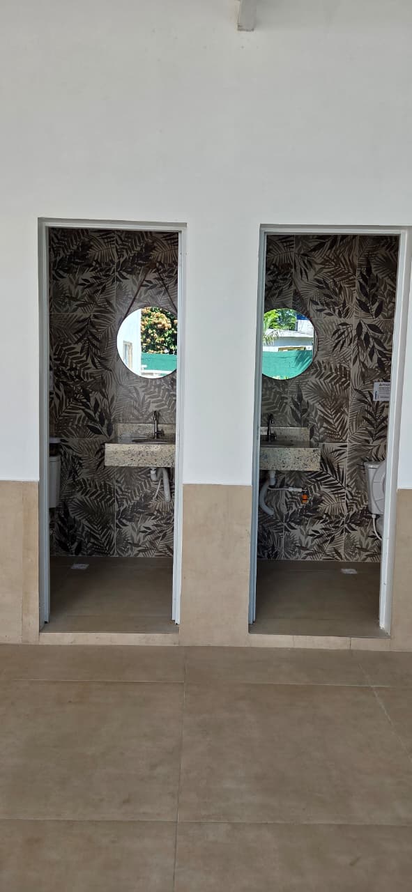 Banheiros externos com papel de parede tropical